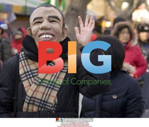 Chinese woman wears Obama mask in Beijing