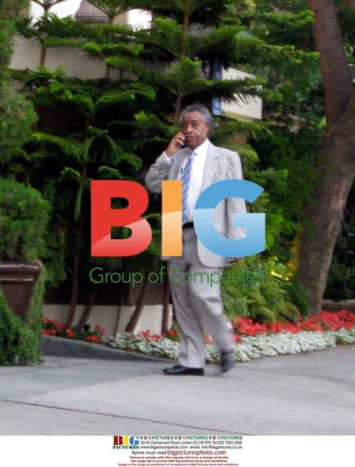 Al Sharpton on phone outside hotel