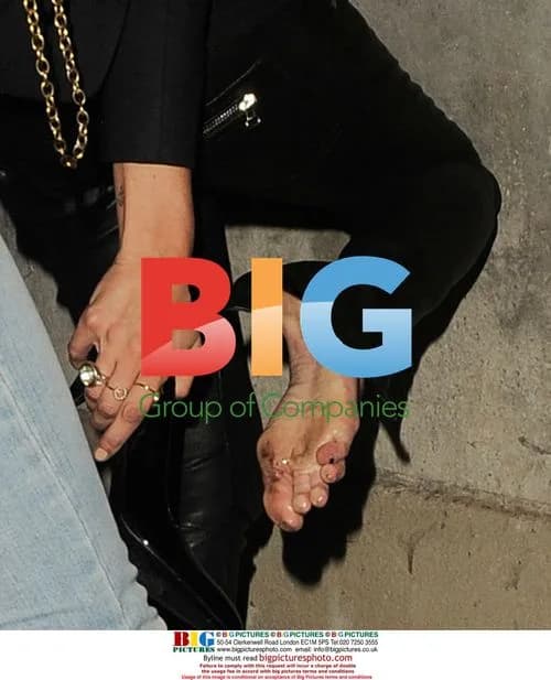Kate Moss has trouble with shoes at Lily Allen gig