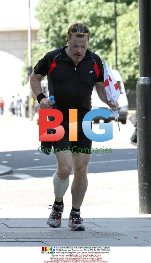 Eddie Izzard jogging with England flag in London