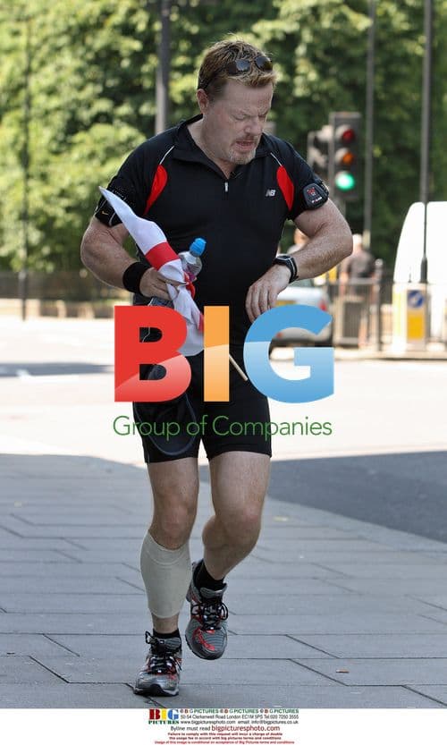Eddie Izzard runs with England flag in London