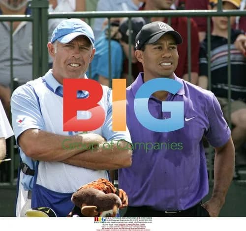Tiger Woods and caddy wait on first tee