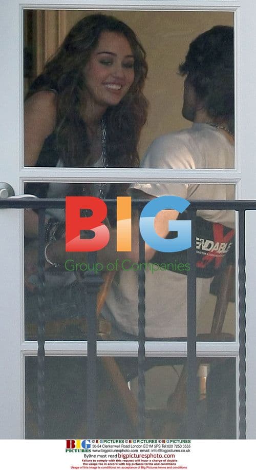 Miley Cyrus and Justin Gaston kissing