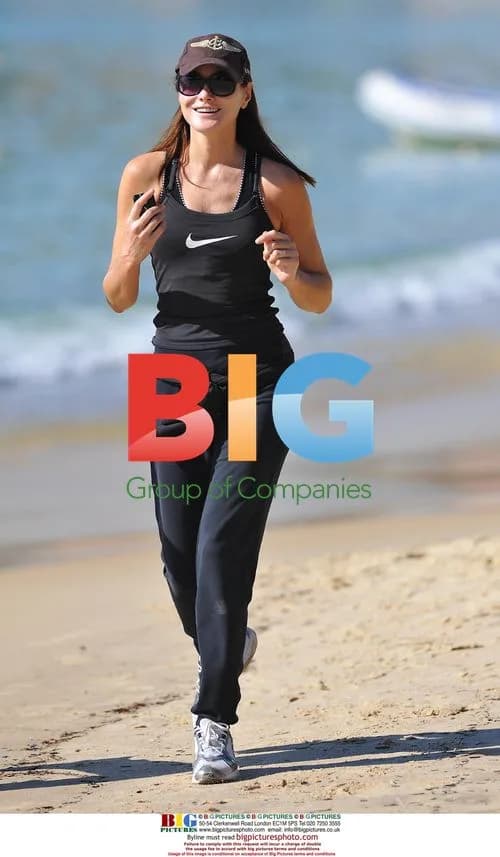 French President Sarkozy and wife Carla jog on beach