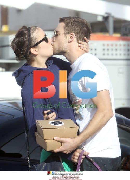 Celebrities Jessica Stroup and Dustin Milligan share a kiss